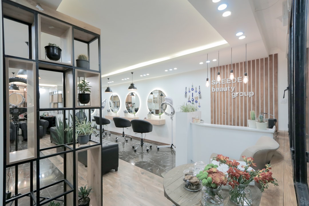 Inside The Classic Unisex Salon — a room filled with furniture and vase of flowers on a table